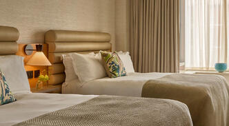Guest room at The River Lee Hotel, showcasing a bright and stylish setup with two single beds