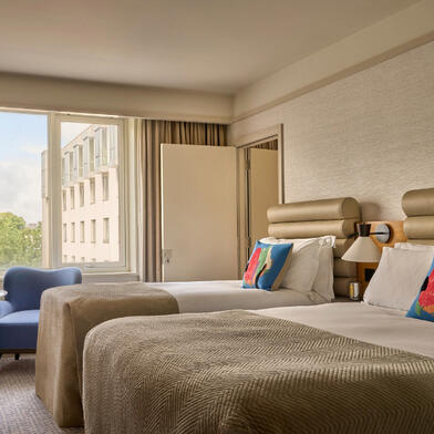 A newly refurbished guest room at The River Lee Hotel featuring one double bed, one single bed, and modern decor.