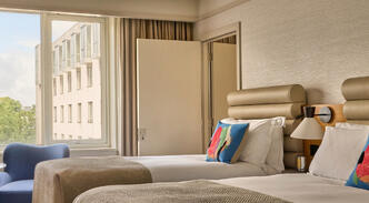 A newly refurbished guest room at The River Lee Hotel featuring one double bed, one single bed, and modern decor.