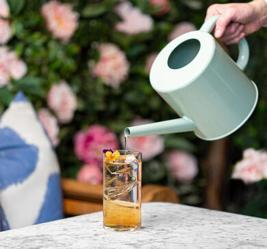 cocktail being poured from a watering can