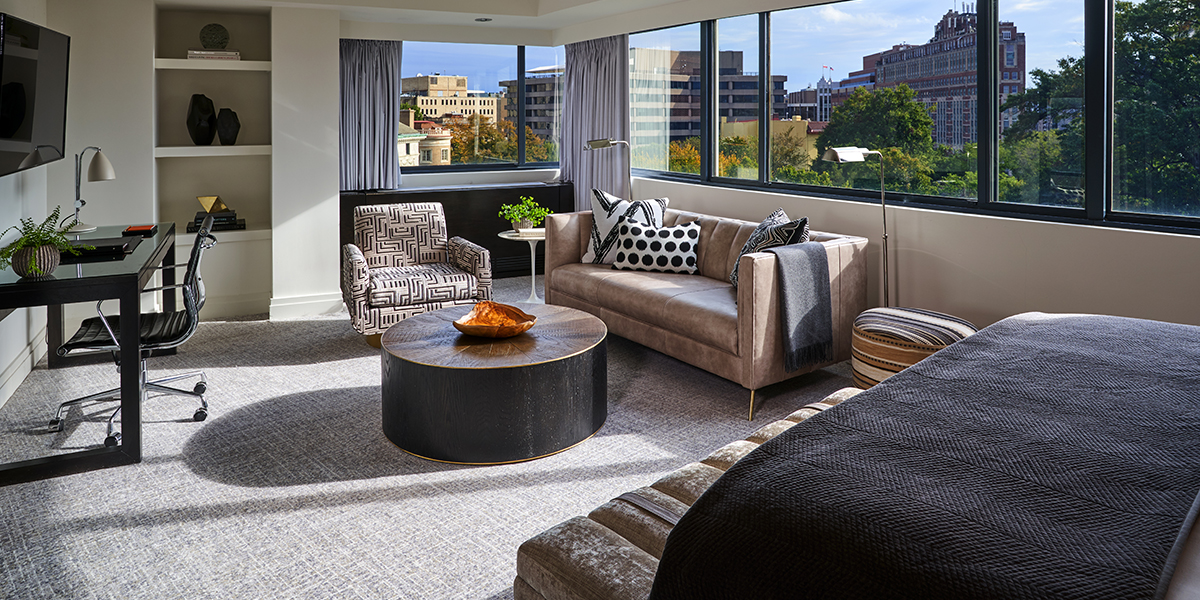 Modern Junior Suite at The Dupont Circle showcasing an open-plan bedroom and living area bathed in bright, natural morning light.