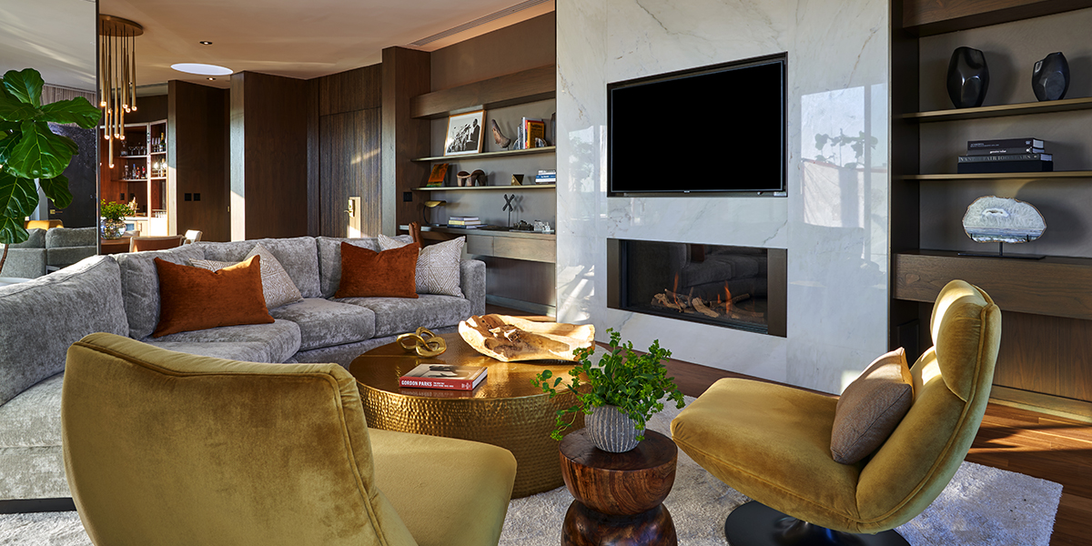 Modern residential-style living room in the Penthouse at The Dupont Circle, featuring elegant furniture, a large TV, and art-forward decor.