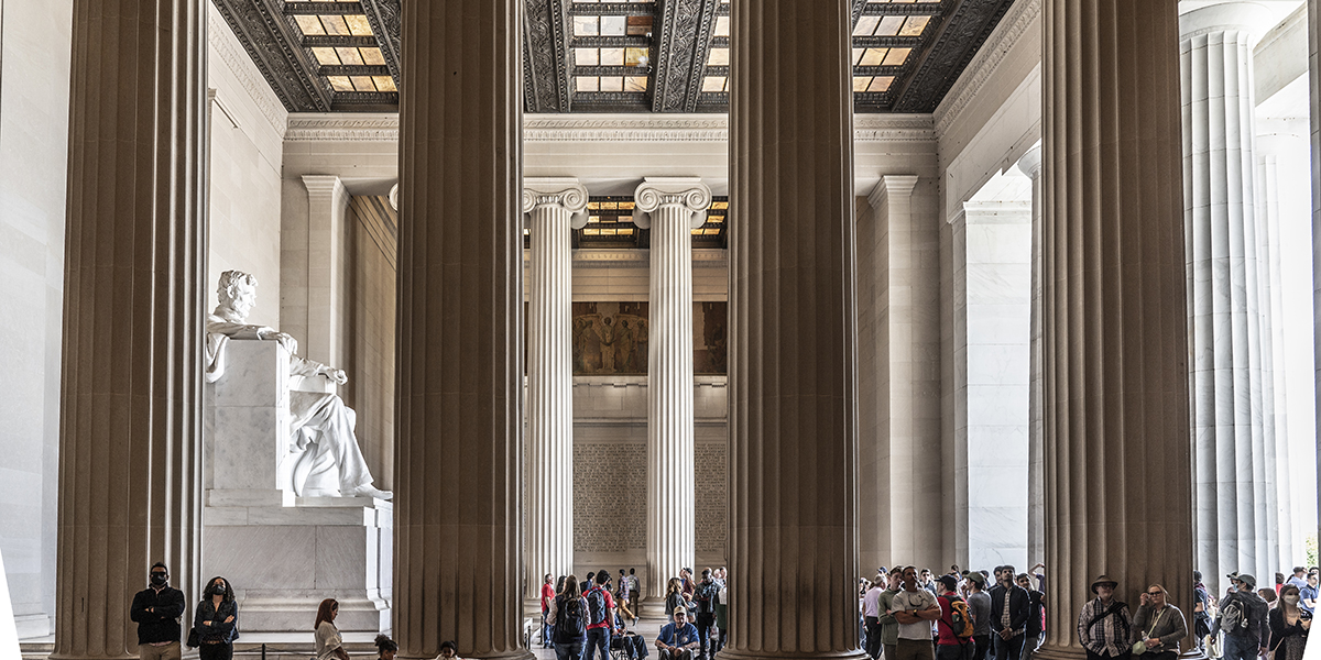 Interior view of the Lincoln Memorial in Washington, DC with visitors admiring the statue of Abraham Lincoln.