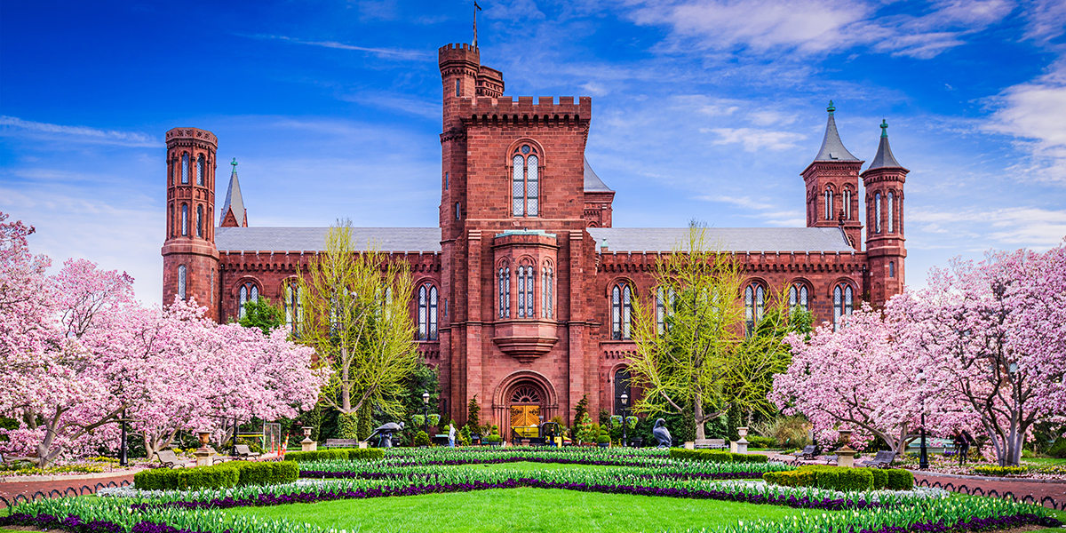 Exterior view of the Smithsonian Castle in Washington, DC, showcasing its historic architecture and landscaped ground in spring
