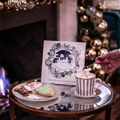 Festive hot chocolate and Christmas cookies beside a decorated fireplace at The Bloomsbury.