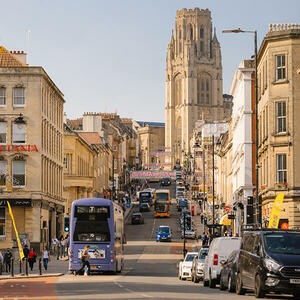 A bustling view of Bristol City Centre's high street, showing a vibrant blend of well-known high street stores and independent boutiques