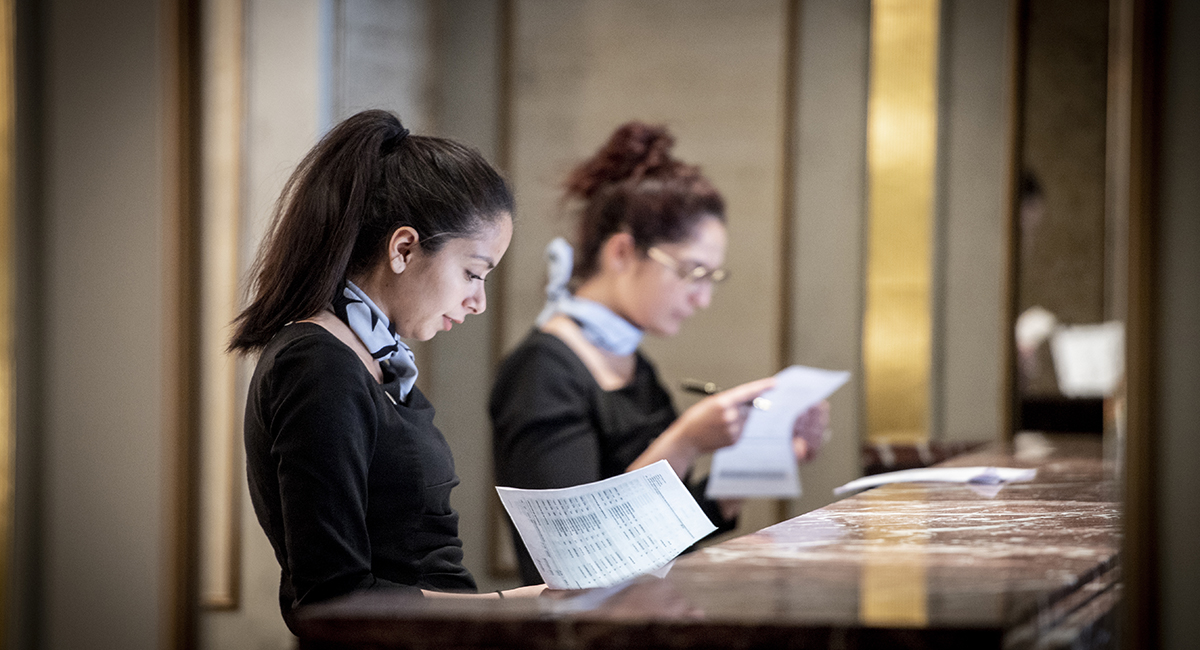 Two dedicated women from The Doyle Collection team working at a polished counter, reflecting the group's recognition as one of the UK's Best Workplaces for Women