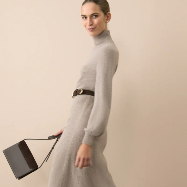 Woman wearing a cream winter dress with a belt and carrying a brown bag, styled for a Friendsgiving gathering at The Dupont Hotel, Washington DC