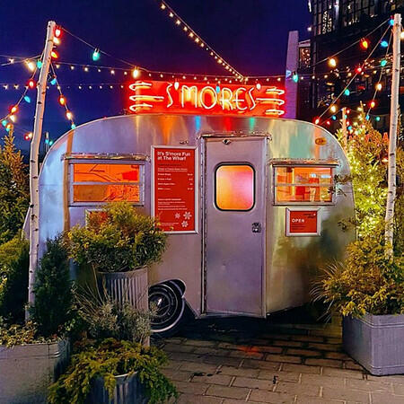 The Caps Campfire s’mores trailer glowing at night at The Wharf,