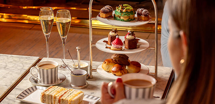 Festive Afternoon Tea served in The Coral Room at The Bloomsbury, with a guest enjoying the experience.
