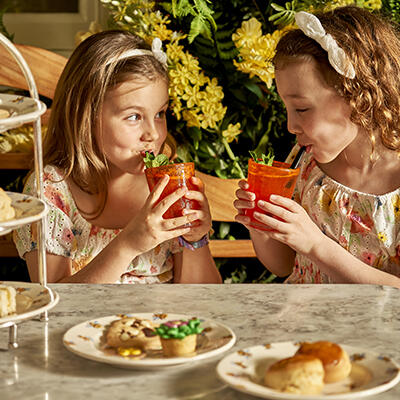 Two girls enjoying a colorful and fun selection of tasty treats for a kids' afternoon tea.
