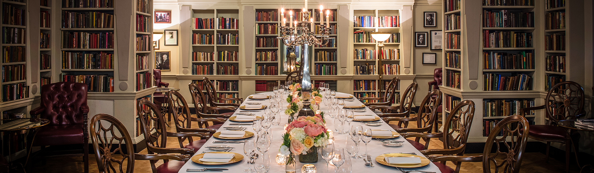 An intimate event setup in the Seamus Heaney Library at The Bloomsbury, featuring elegant dining tables and classic bookshelves in a unique, luxury West End London venue.