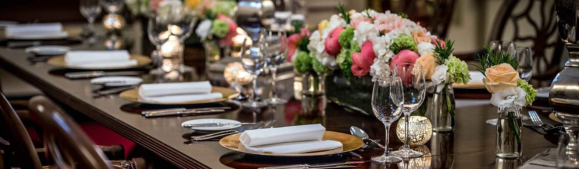 An elegant private dining setup within The Chapel at The Bloomsbury, showcasing a candlelit long table with sophisticated decor and flowers