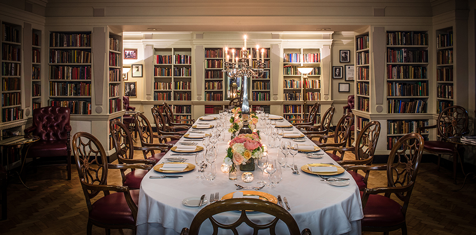 The intimate Seamus Heaney Library at The Bloomsbury set for a private event, featuring elegant table arrangements surrounded by classic bookshelves in a luxury West End venue.