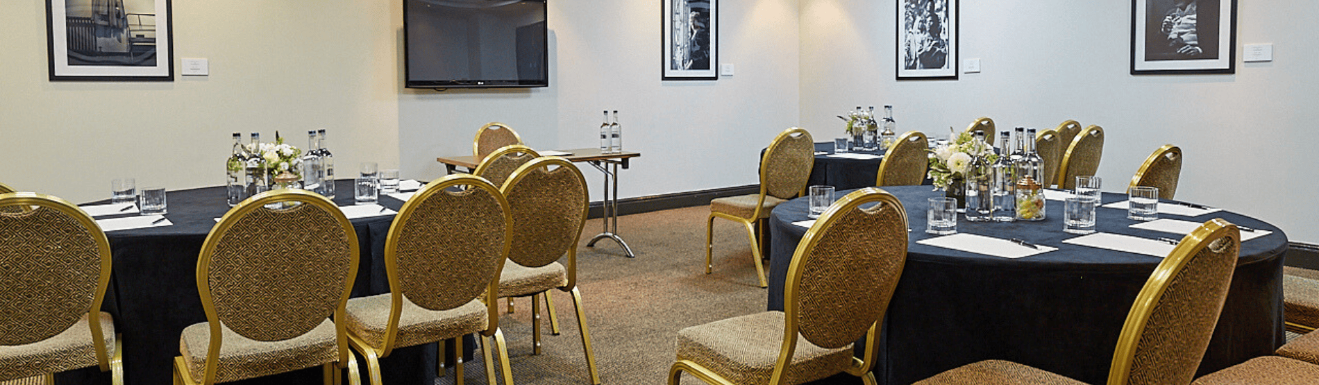 A corporate meeting room setup in The Bedford Studio at The Bloomsbury Hotel. The room features circle tables with chairs set up for a corporate event.