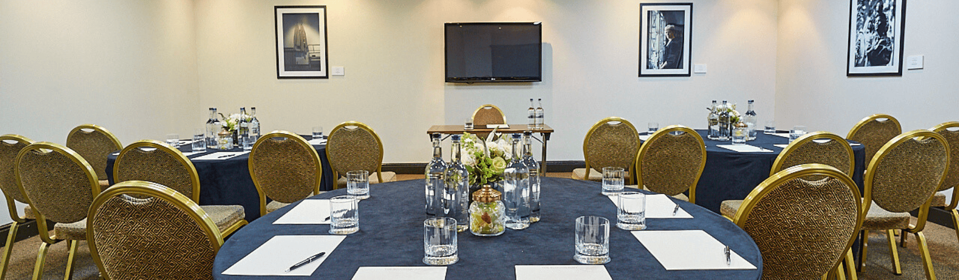 A corporate meeting room setup in The Bedford Studio at The Bloomsbury Hotel. The room features circle tables with chairs set up for a corporate event.