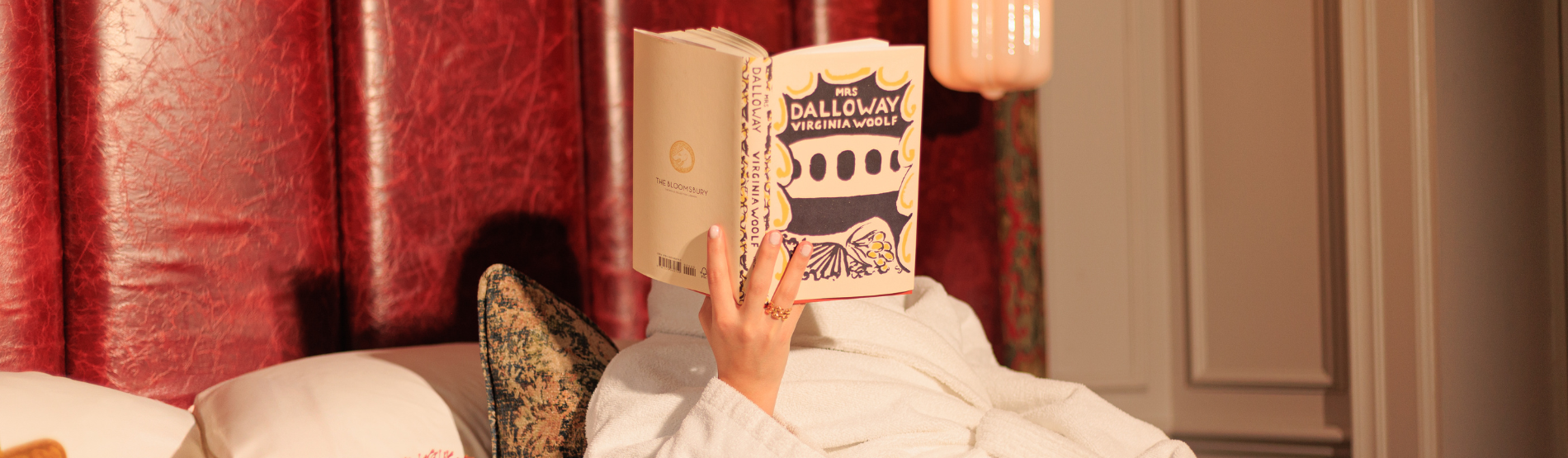 A woman relaxed in her suite at The Bloomsbury hotel, enjoying the Mrs. Dalloway book.