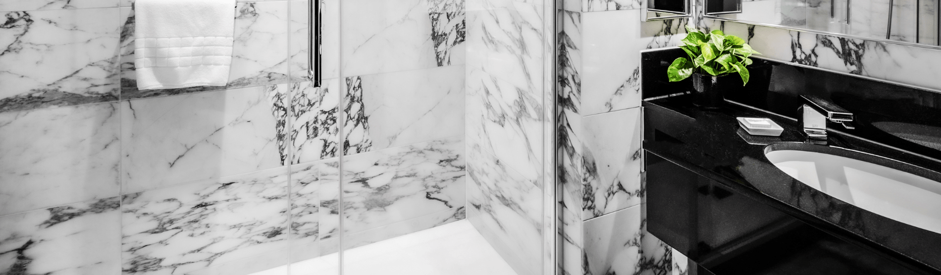 A bathroom at The Bloomsbury Hotel for The Cosy Room featuring a black sink and a white-and-black marble bathtub.