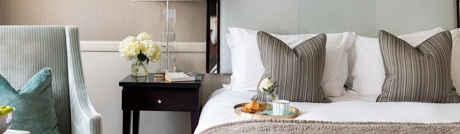 Cozy hotel room in Bristol with a cup of coffee on the bed, perfect for a Spring Escape getaway.