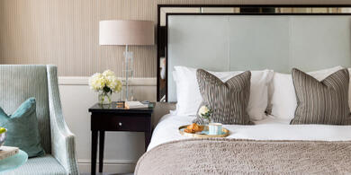 Cosy hotel room at the Bristol Hotel with a cup of coffee on the bed, perfect for a Spring Escape getaway. 