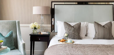 Cosy hotel room at the Bristol Hotel with a cup of coffee on the bed, perfect for a Spring Escape getaway. 