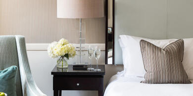 Bedside table with champagne in suite