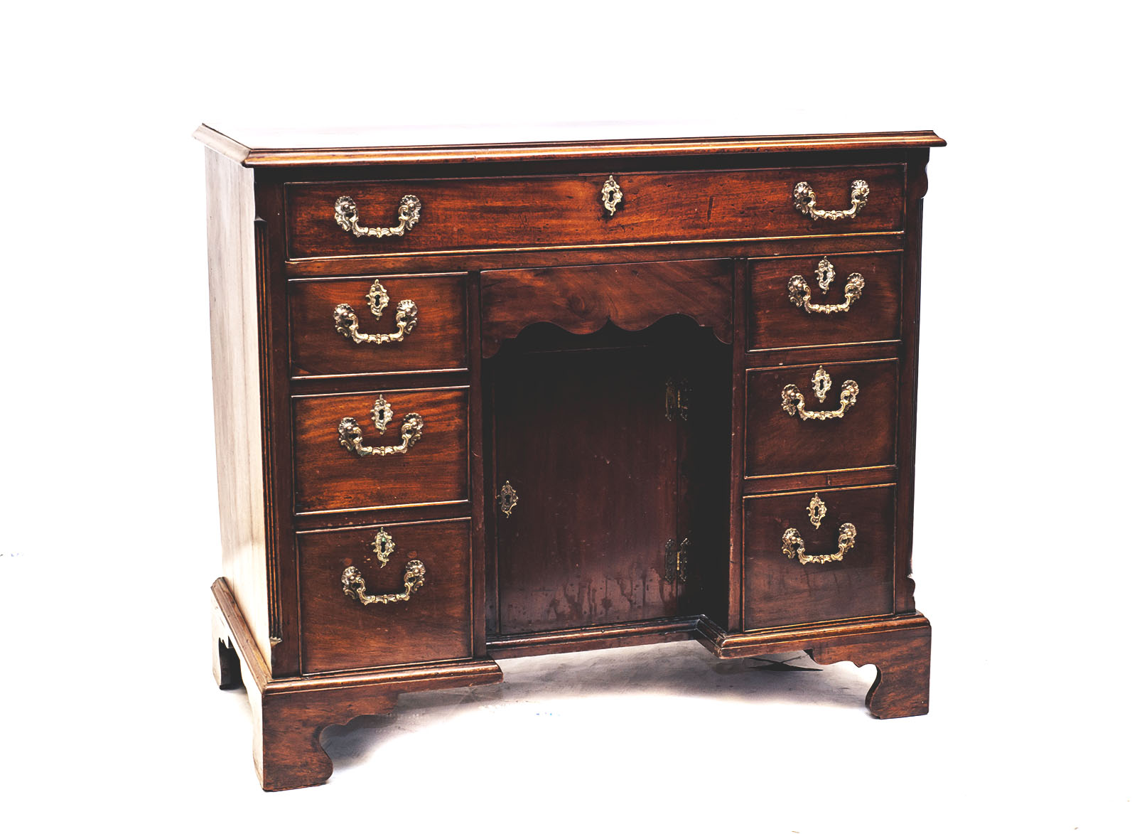 IM Chaney - A dark wood chest of drawers with gold handles