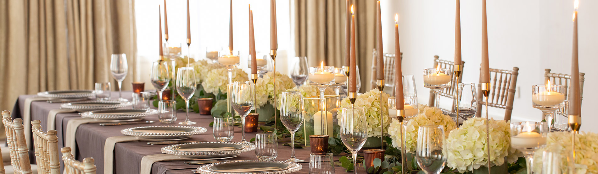 Long table beautifully decorated with white hydrangeas and candles
