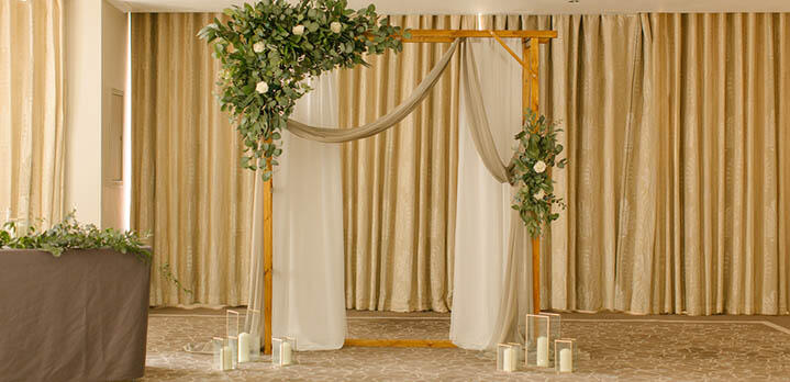 Wooden wedding arch decorated with flowers and foliage