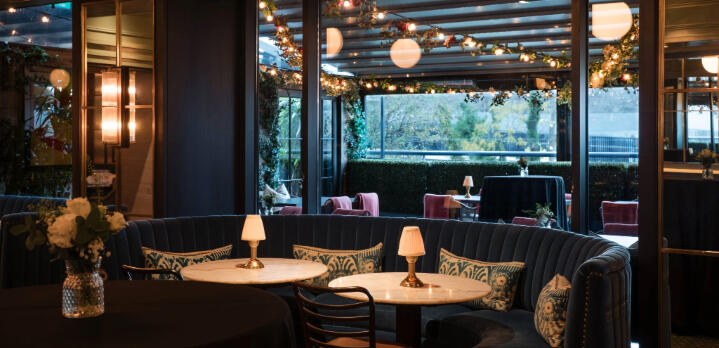 Fine dining table settings and elegant decor inside The Hawthorn restaurant, prepared for dinner.
