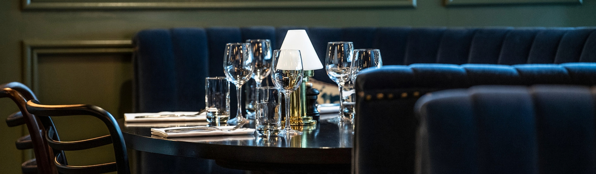 A close-up of a beautifully set table inside The Hawthorn, featuring polished wine glasses and elegant tableware in a refined dining setting