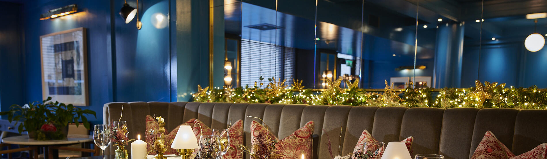 Festive restaurant interior at Croke Park hotel with Christmas lights, candles, and dining settings.