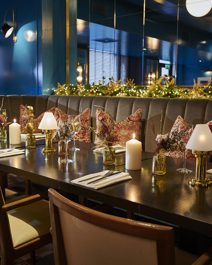 Festive restaurant interior at Croke Park hotel with Christmas lights, candles, and dining settings.