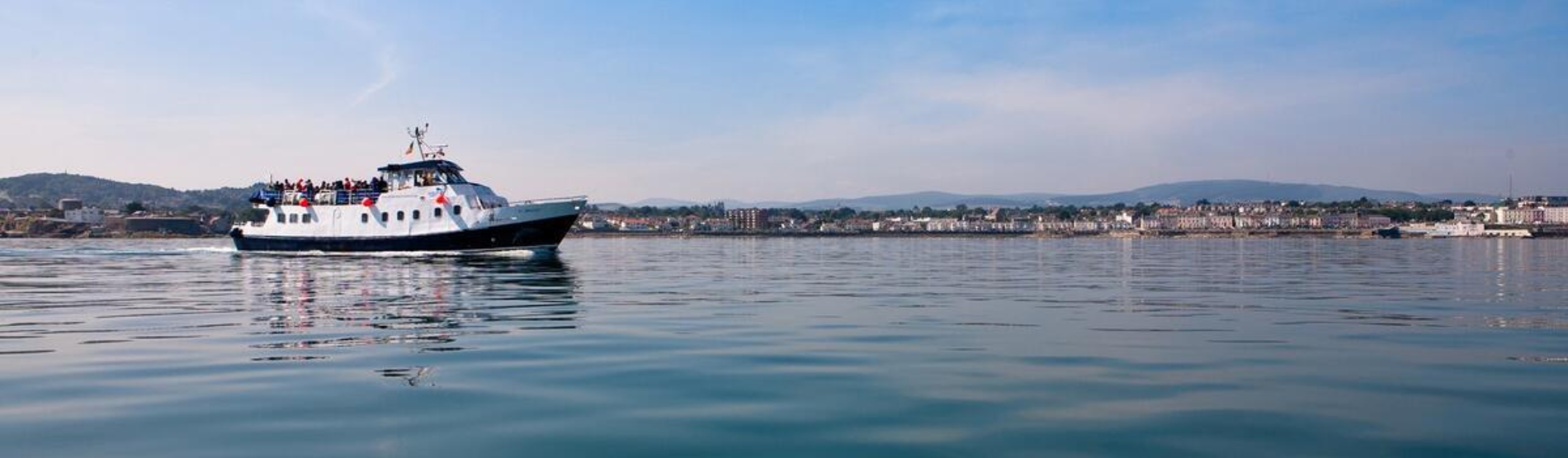 Dublin Bay Cruise boat traveling on the sea from Howth to Dún Laoghaire, featured in the family staycation package at The Croke Park hotel.