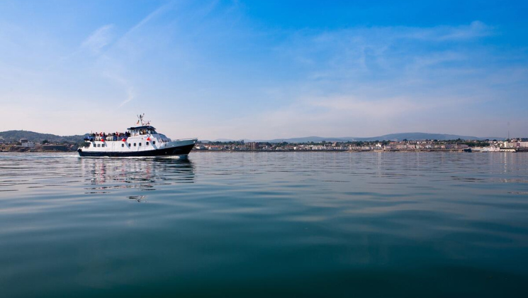 Dublin Bay Cruise boat traveling on the sea from Howth to Dún Laoghaire, featured in the family staycation package at The Croke Park hotel.