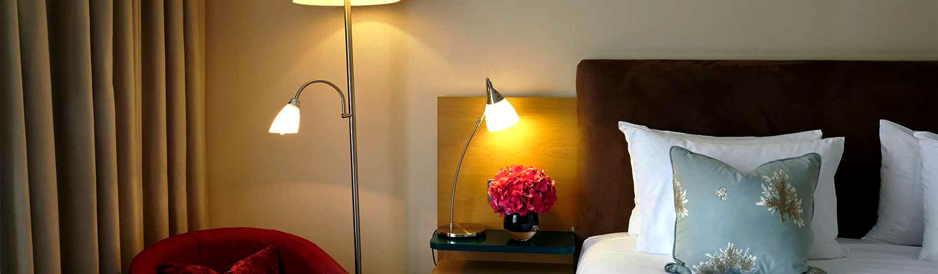 Bedroom detail with bedside lamp and pink floral arrangement
