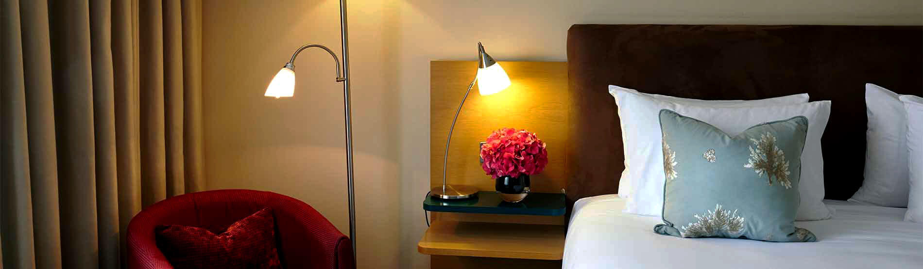 bedroom detail with bedside lamp and pink floral arrangement