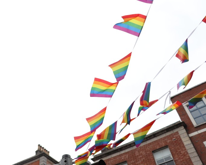 Rainbow bunting hanging from old red brick buildings