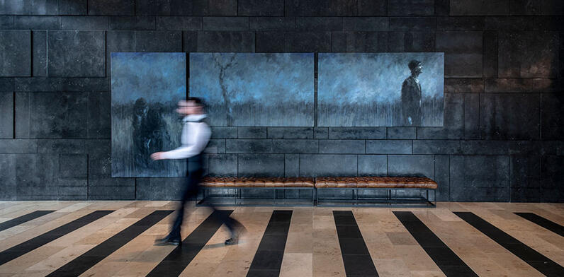 man walking in front of painting in the hotel lobby
