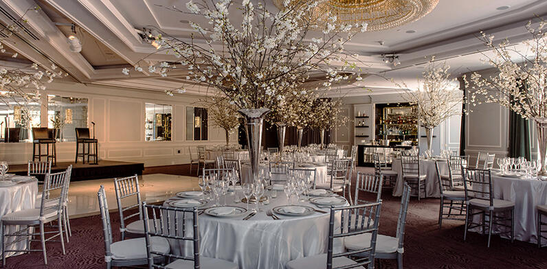 Tables set for Wedding breakfast with white table cloths and spring blossom center piece
