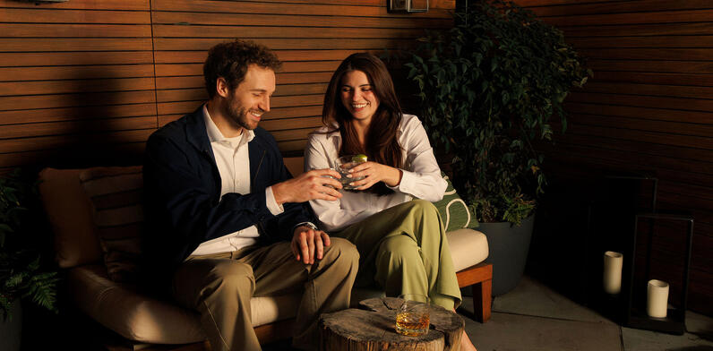 Toasting to Irish Heritage Month: A couple relaxes with drinks in the lush garden setting of The Dupont Circle.