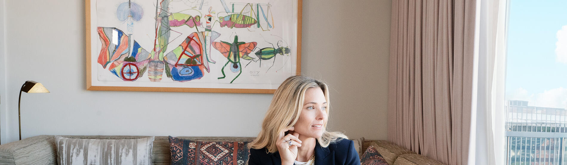 Veronica Beard in a navy blazer and jeans in the Dupont Circle hotel seated on a sofa inside the Penthouse Suite.