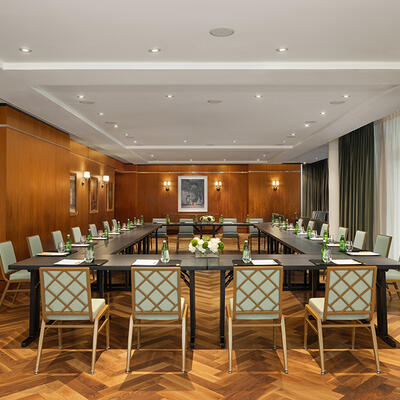 Hollow square meeting setup in the Glover Park room, featuring four sides of tables and chairs facing inward for a collaborative session.