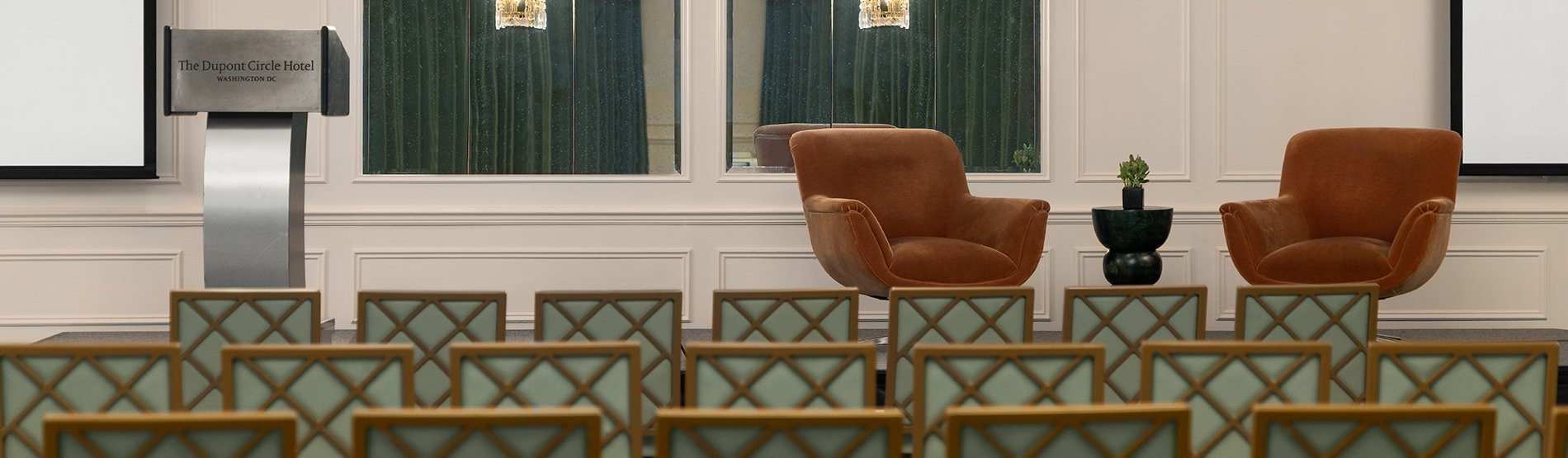 Theatre-style seating in The Dupont Ballroom oriented toward a stage with two sofas, prepared for a speech or panel discussion.