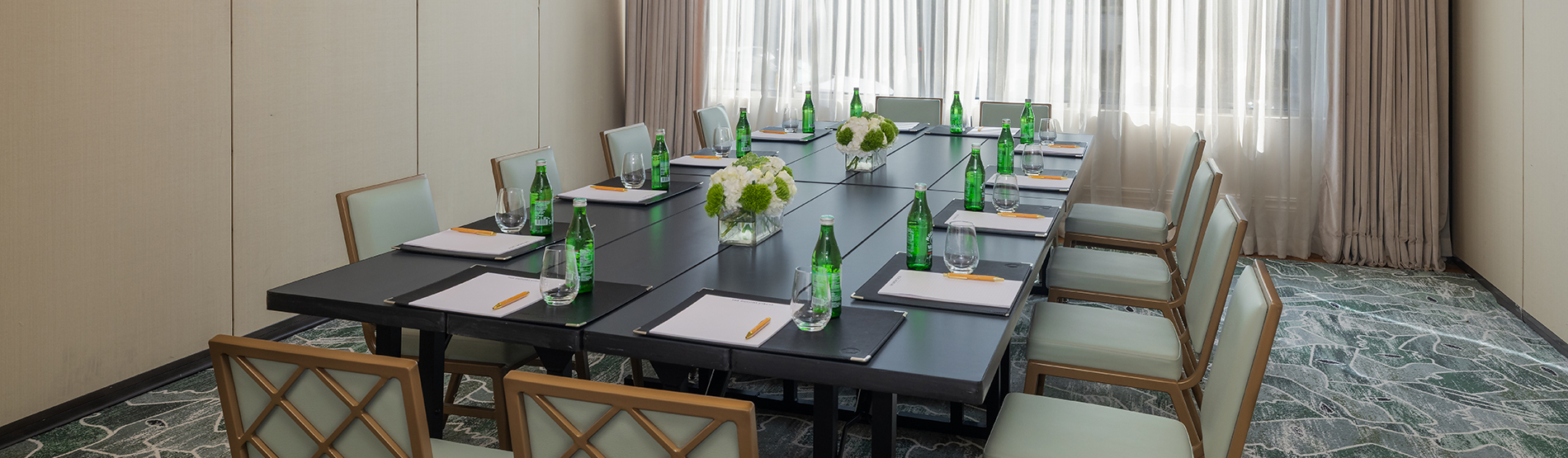 The Foxhall room configured for a meeting breakout, showing half of the space occupied by a long rectangular table and chairs. The orderly arrangement is designed for team workshops or executive breakout sessions.