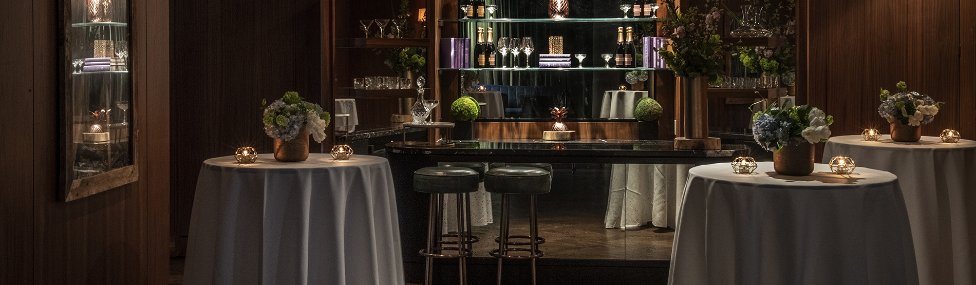 An upscale bar area in Glover Park featuring high-top tables and stools, with a clean, modern bar setup in the background ready for a private event.