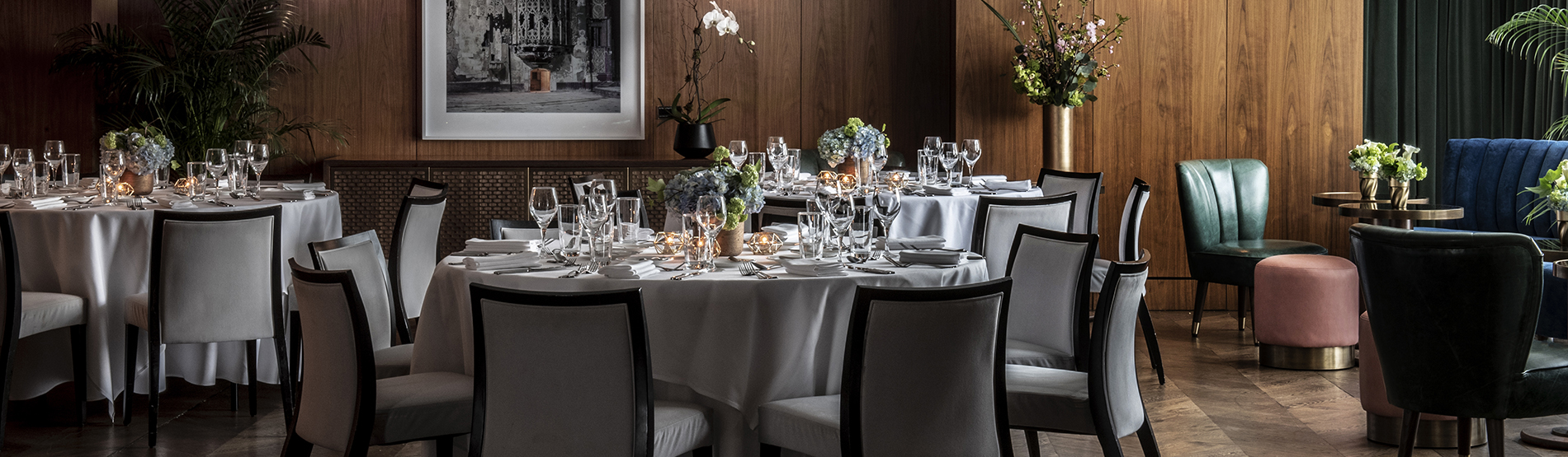 An inviting social setup in the Glover Park room, where tables are neatly prepared for a private dinner. Natural light from the large windows enhances the elegant table arrangements, making the space feel bright and celebratory.