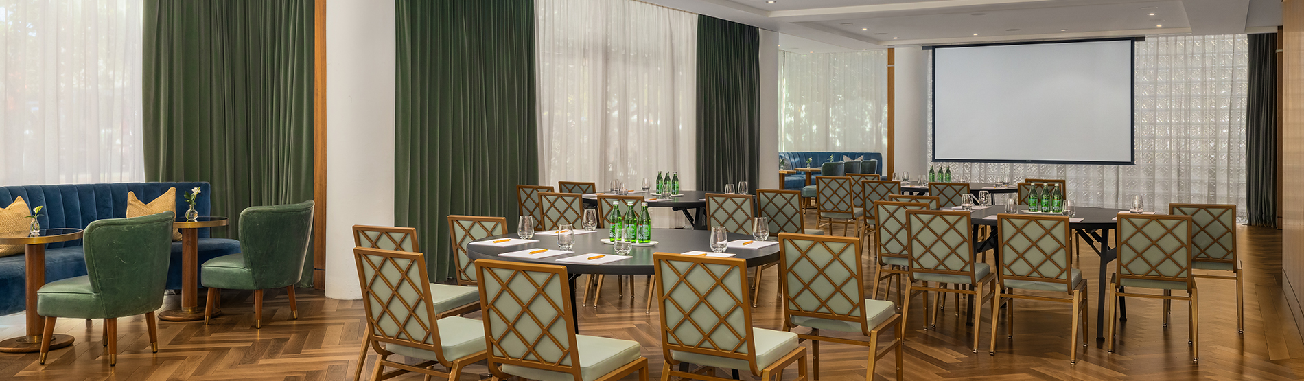 An airy view of the Glover Park room set for a seminar. The crescent round tables are neatly arranged to maximize visibility and collaboration, illuminated by sunlight from the floor-to-ceiling windows.