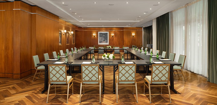 A hollow square table setup in the Glover Park room at The Dupont Circle Hotel, with chairs neatly arranged around the outside for a group discussion or executive session.