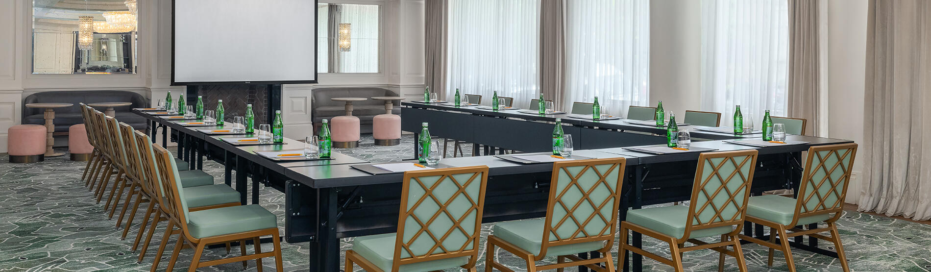 U-shaped table configuration for a meeting in the Foxhall room, highlighting two large round ceiling lights and spacious windows.